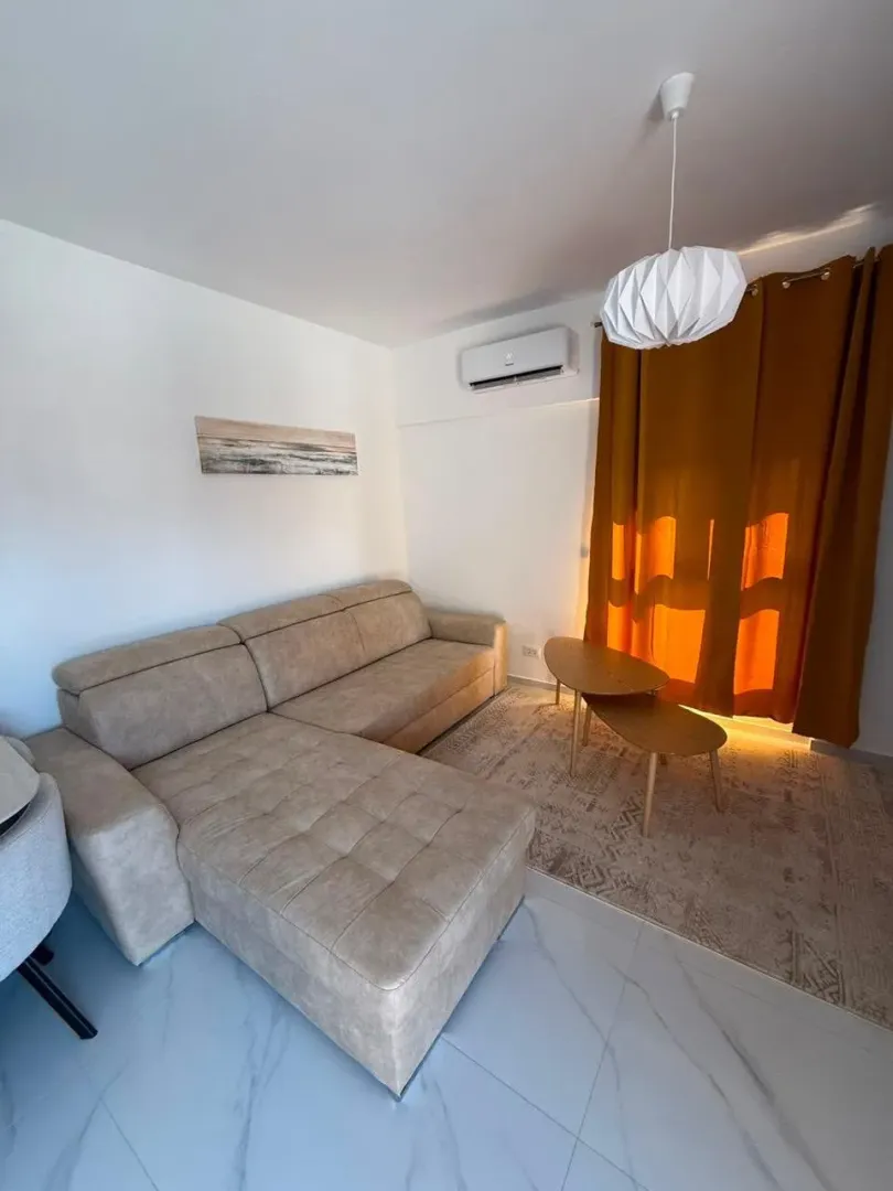 Living room with a sectional sofa, coffee table, and yellow curtains.