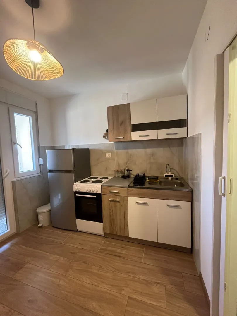 Small equipped kitchen with a refrigerator and a stove.