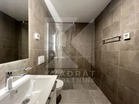 Moderno opremljeno kupatilo sa tuš kabinom obloženom tamnim pločicama. - image 25