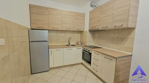 Kuhinja opremljena drvenim elementima i osnovnim aparatima. - image 7