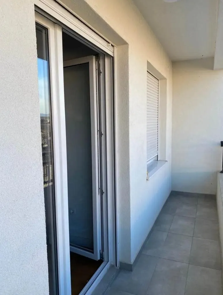 Unfurnished balcony space with ceramic tiles and balcony doors.