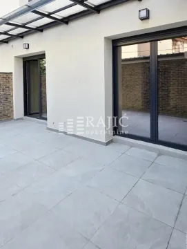 Popločana terasa ispred kuće sa staklenim kliznim vratima i nadstrešnicom. - image 18
