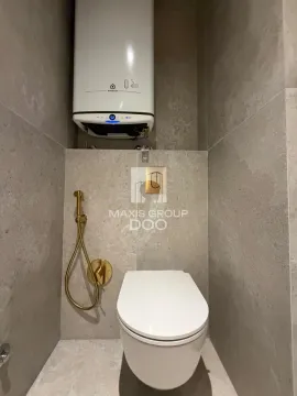 Small bathroom with a wall-hung toilet and a water heater on the wall. - image 10