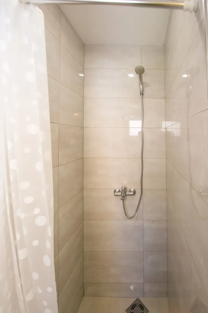 Modernly equipped shower cabin with light tiles.