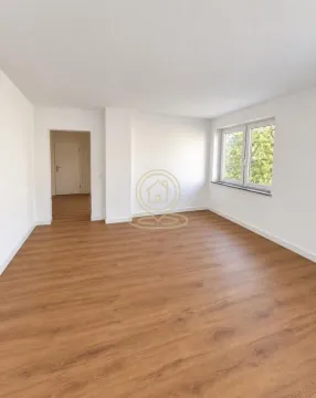Prazna soba sa belim zidovima i drvenim podom. - image 4