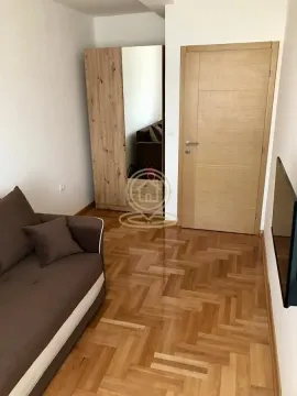 Dnevna soba sa kaučem, ormarom i drvenim parketom. - image 6