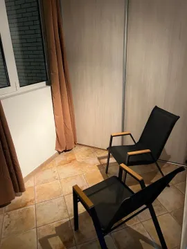 Covered terrace with ceramic tiles and outdoor seating. - image 2