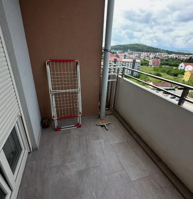 Smaller tiled balcony with a clothes dryer and a view of the neighborhood.