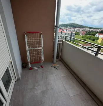 Smaller tiled balcony with a clothes dryer and a view of the neighborhood. - image 10