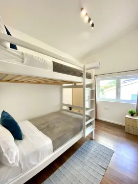 Bright bedroom with a bunk bed and wooden flooring. - image 4