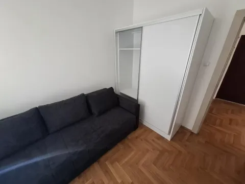 Manja spavaća soba sa tamnim kaučem i belim garderoberom. - image 10