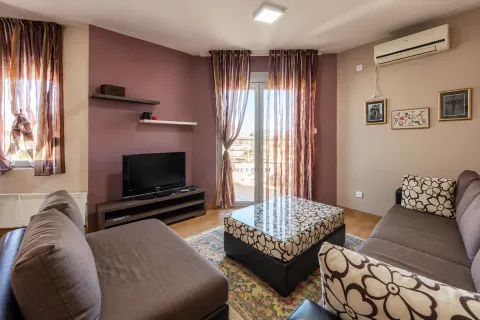 Dnevna soba sa garniturom za sjedenje, TV-om i izlazom na terasu. - image 2