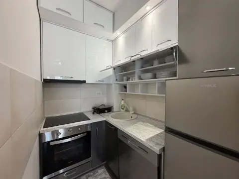 Small modern kitchen with white and dark cabinets and built-in appliances. - image 3