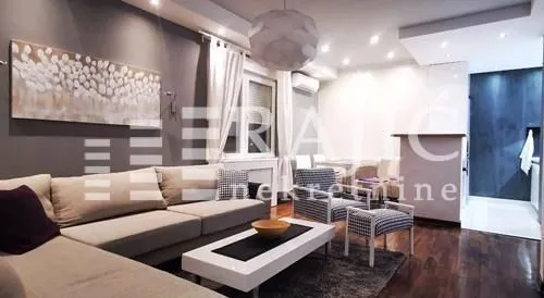 Modern living room with a sofa set and a dining area in the background.