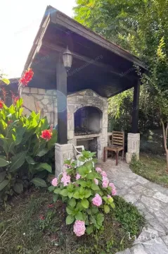 Natkriveni prostor sa roštiljem i kamenom stazom u dvorištu. - image 2