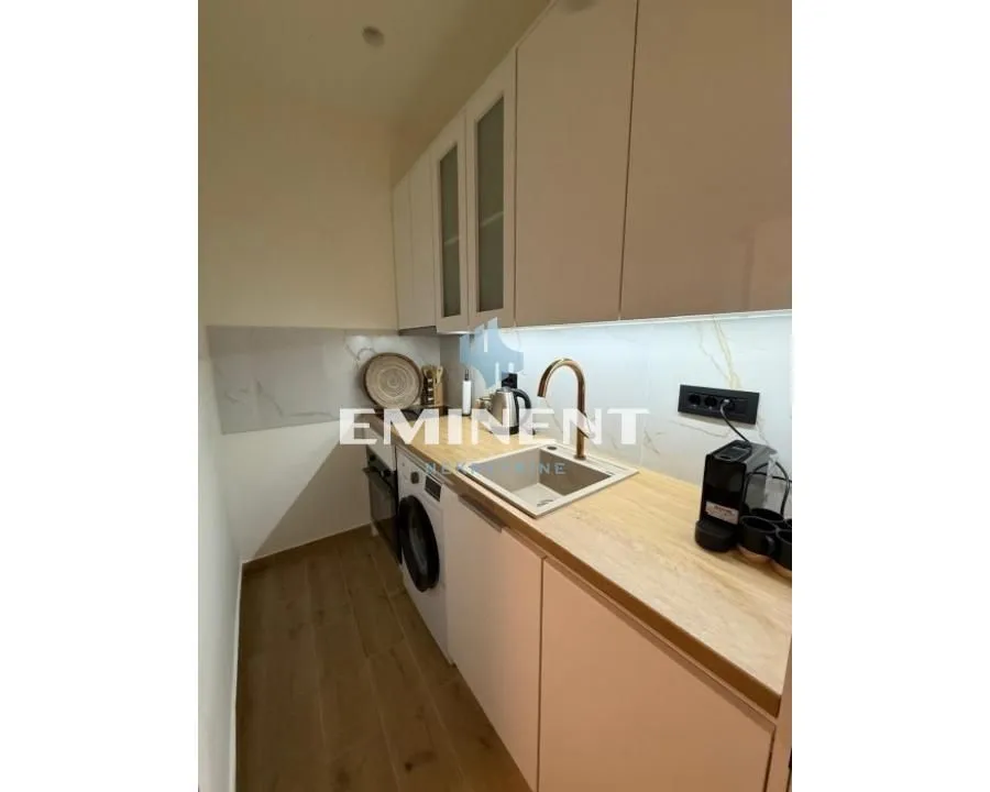 Small kitchen with white cabinets and a built-in washing machine.