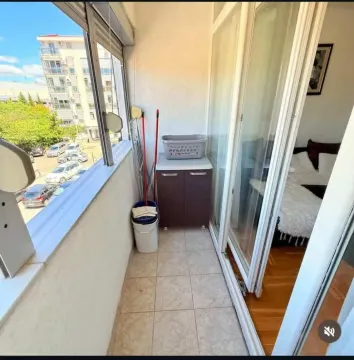 Enclosed balcony with tiled flooring and city view. - image 4