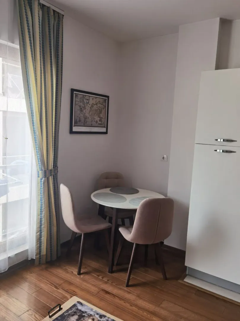 Small dining area with a table and chairs by the window.