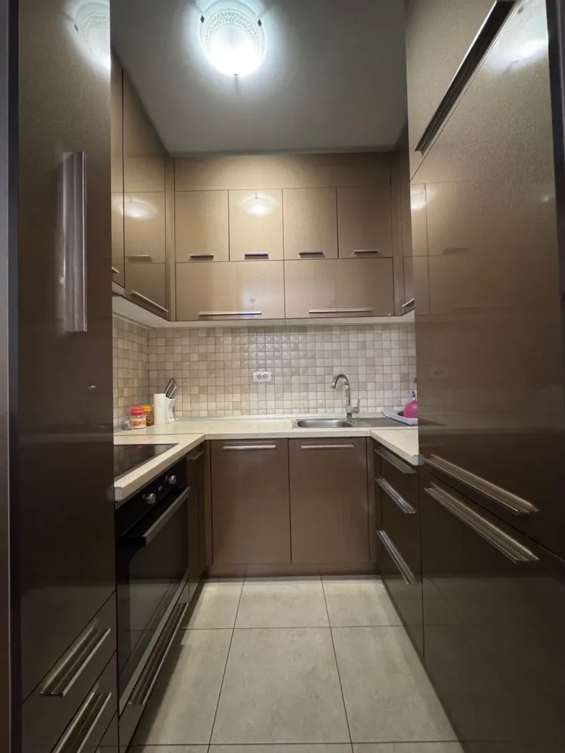 Small kitchen with brown cabinets and built-in appliances.