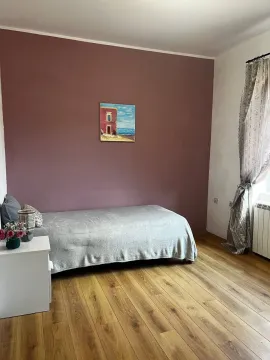 Nameštena spavaća soba sa krevetom i drvenim podom. - image 3