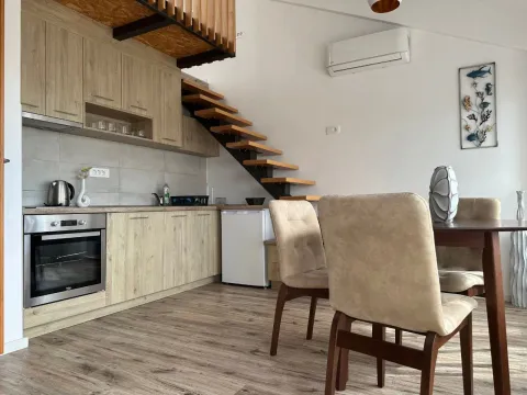 Living room with kitchen and loft stairs. - image 7