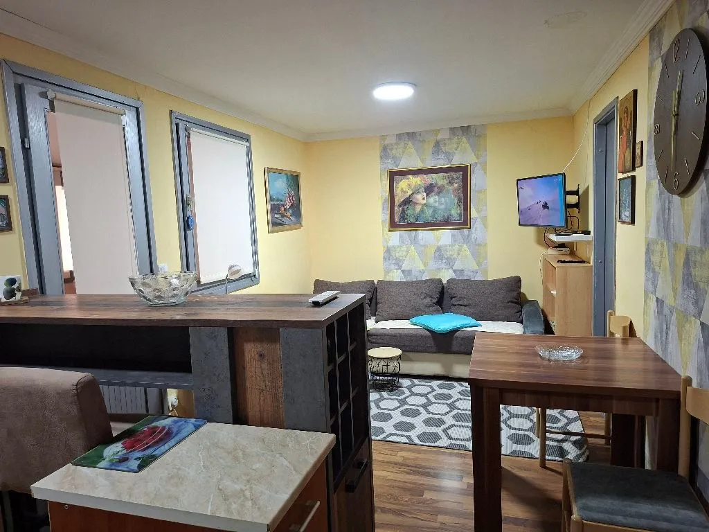 Living room with sofa, dining table, and breakfast bar.