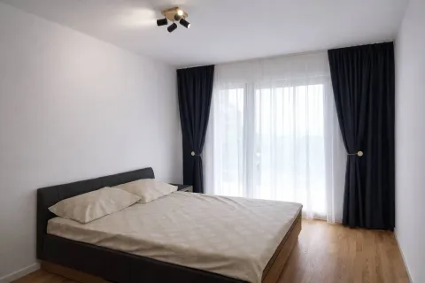 Svijetla spavaća soba sa bračnim krevetom i tamnim zavjesama. - image 4