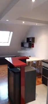 Kitchen with a bar counter and dining table in the attic. - image 2