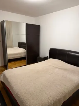 Spavaća soba sa bračnim krevetom i velikim ormarom sa ogledalom. - image 5