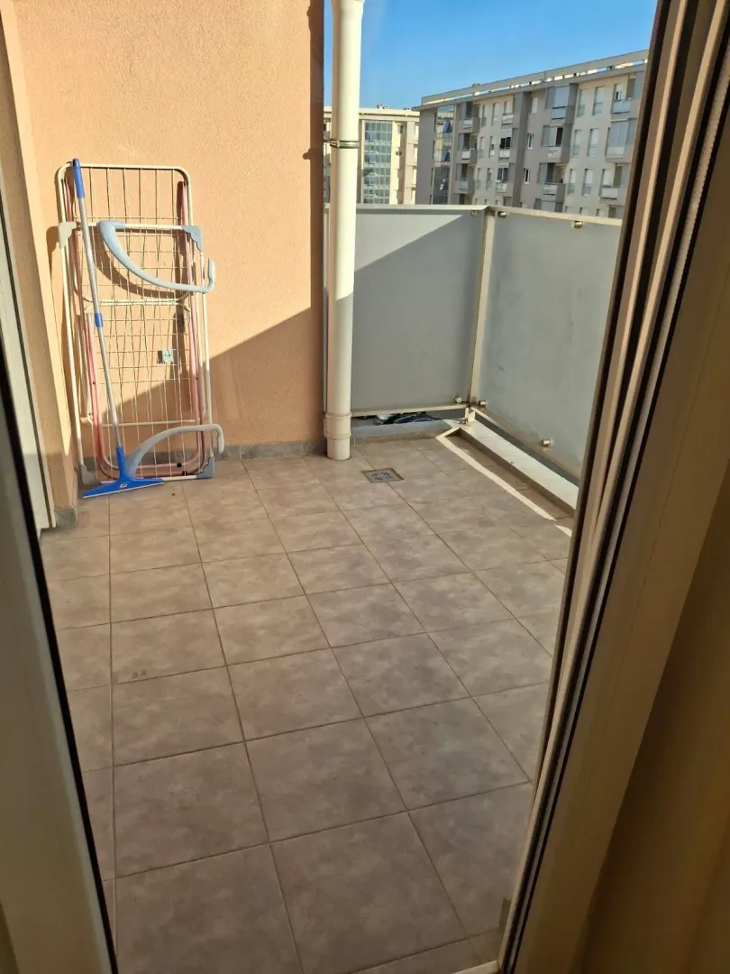 View of a tiled balcony with a clothes drying rack.