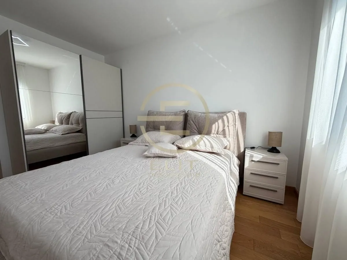 Bedroom with a double bed, nightstands, and a large wardrobe with a mirror.