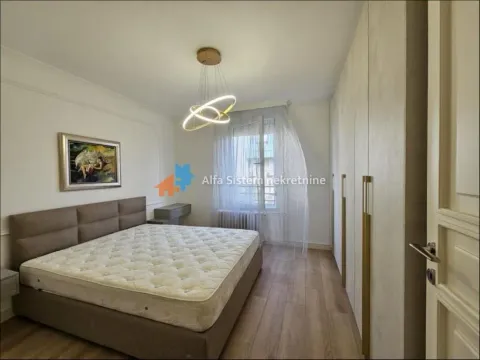Spavaća soba sa bračnim krevetom, velikim garderoberom i modernim lusterom. - image 2