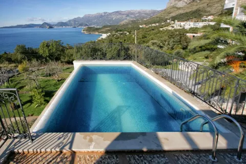 Outdoor pool with a view of the sea and surrounding mountains. - image 14