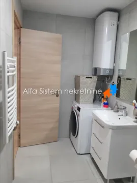 Kupatilo opremljeno umivaonikom, veš mašinom i bojlerom. - image 3