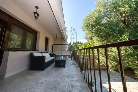 Spacious covered terrace with seating furniture and a view of greenery. - image 7