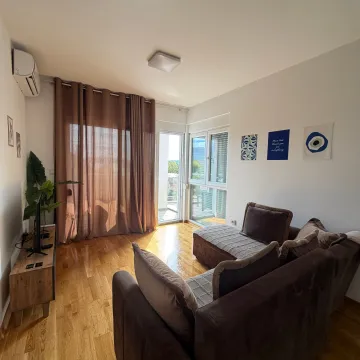 Svijetao dnevni boravak sa ugaonom garniturom, drvenim podom i izlazom na terasu. - image 3