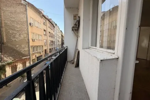 Narrow balcony with a black metal railing overlooking the street and buildings. - image 15