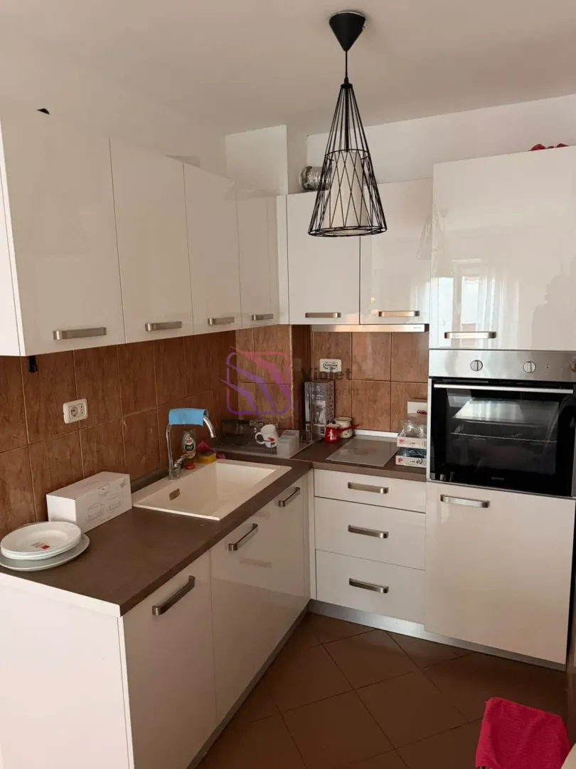 Small kitchen with white units and a built-in oven.