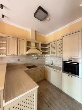 Kuhinja opremljena drvenim elementima u bež tonovima i ugradnim uređajima. - image 3