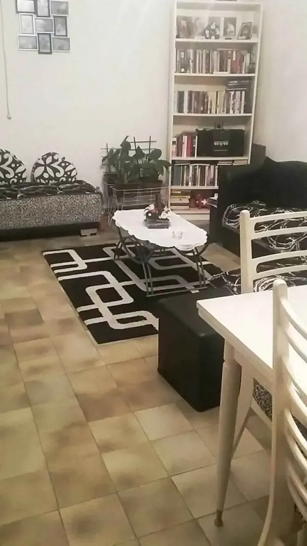 Dnevna soba sa garniturom za sjedjenje, klub stolom i policom za knjige.
