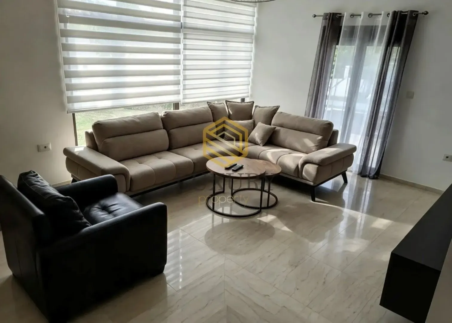 Living room with a sofa and large windows.