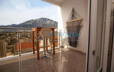 Natkriveni balkon sa garniturom za sjedenje i pogledom na planinu i grad. - image 16