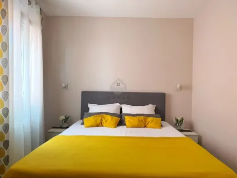 Namještena spavaća soba sa bračnim krevetom i prozorom sa bijelim i žutim zavjesama. - image 14