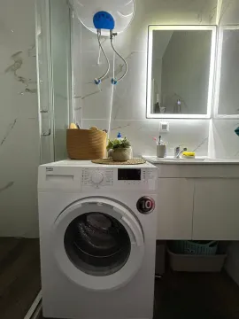 Modern bathroom with a washing machine, washbasin, and shower cabin. - image 14