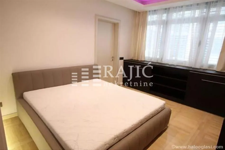 Bedroom with a double bed, wardrobe, and windows.