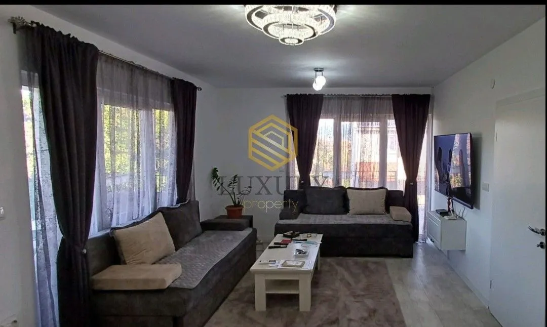 Living room with a sofa set, coffee table, and wall-mounted TV.