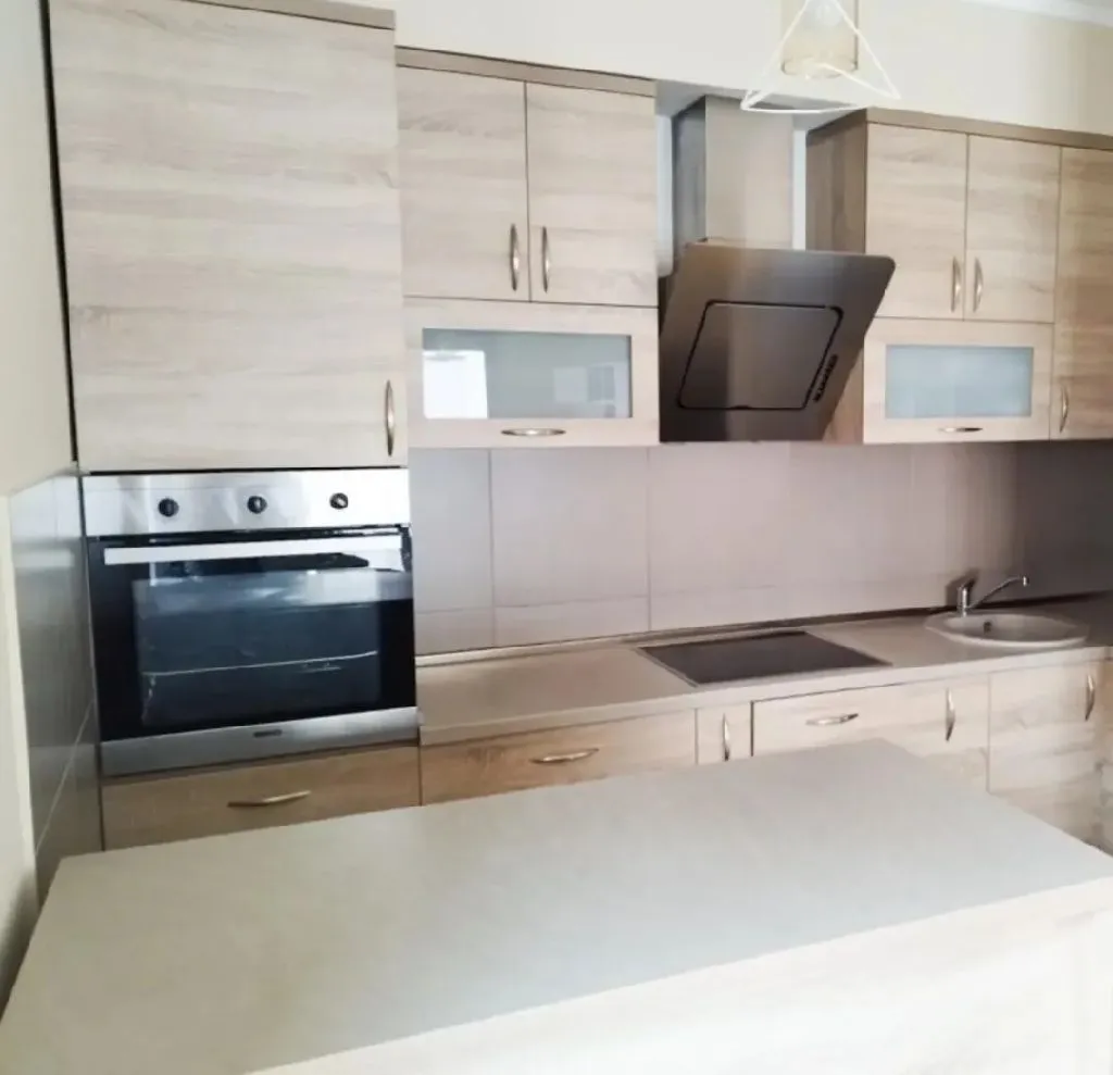 Modern kitchen with wooden cabinetry and built-in appliances.