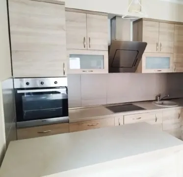 Modern kitchen with wooden cabinetry and built-in appliances. - image 5