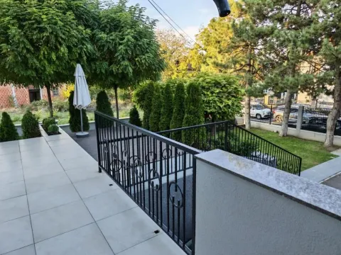 Pogled na popločanu terasu i dvorište puno zelenila. - image 4