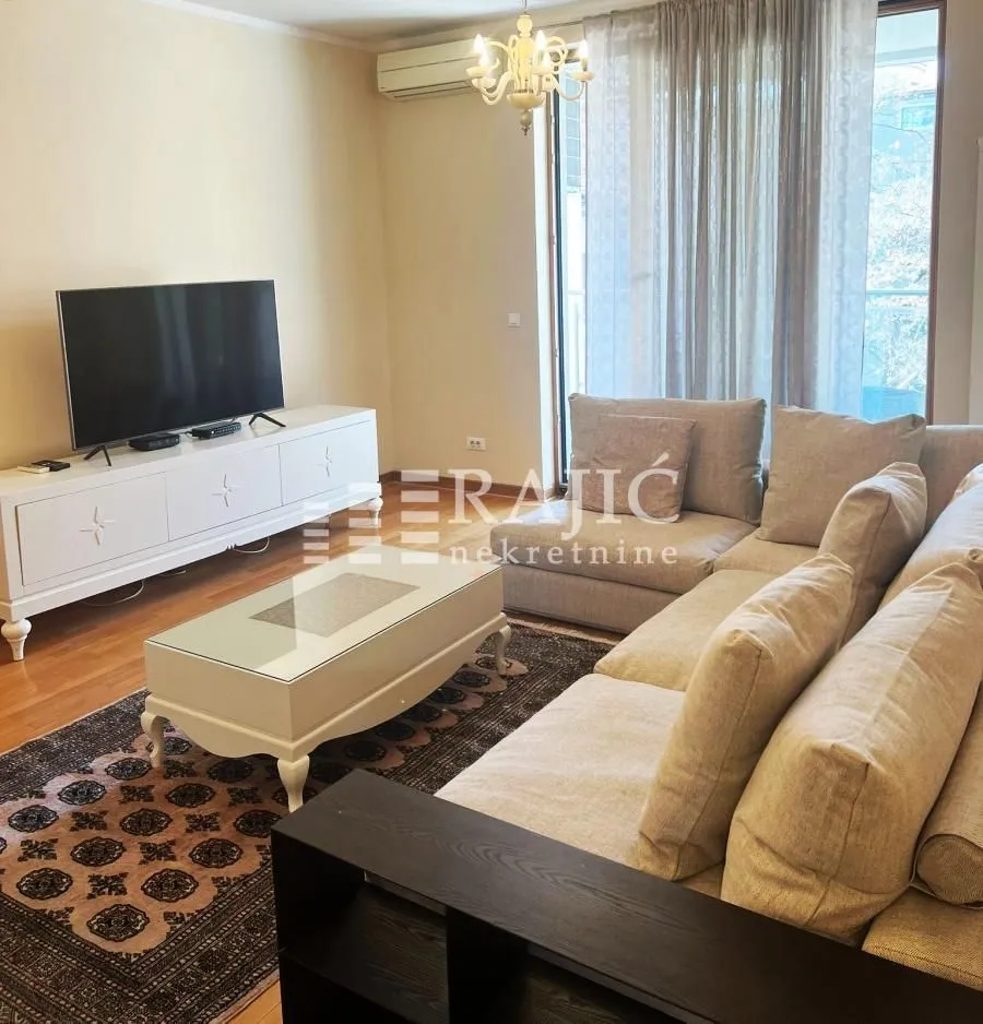Living room with sofa, TV, and access to the terrace.